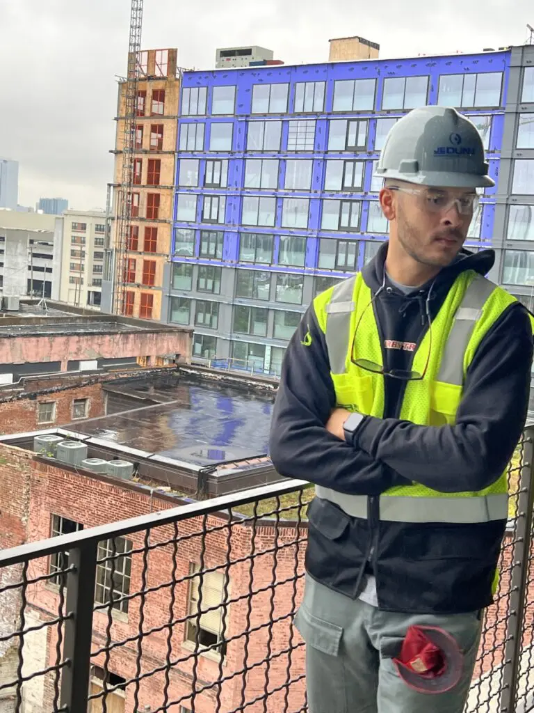 Man on balcony overlooking construction