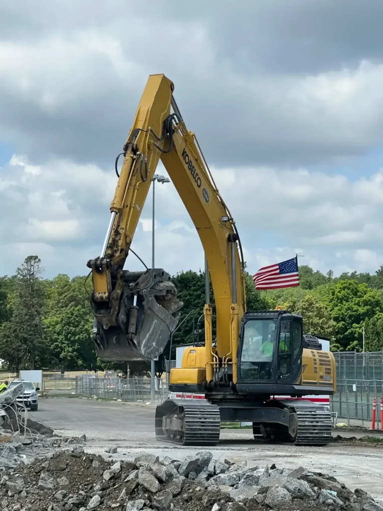 Heavy machinery clearing debris under cloudy sky