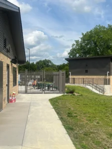 Recreational facility with grass, concrete, and trees